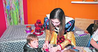 Hutmacherin. Laura Cina half den Kindern beim Schm&uuml;cken ihrer H&uuml;te. 