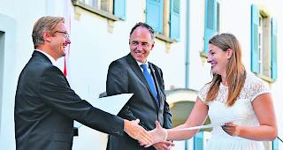 Freudestrahlend. OMS-Direktor Olivier Mermod (links) und Staatsrat Christophe Darbellay &uuml;berreichen im OMS-Garten einer Absolventin das Zertifikat: Freude herrscht. 