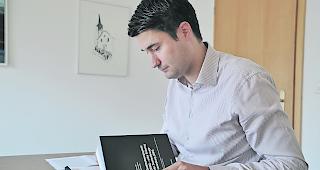 Aron Pfammatter mit dem Kommentarband zum Zweitwohnungsgesetz.