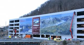 Im Eiltempo. In etwas mehr als einer Stunde wurde am Donnerstag eine runde 580 Quadratmeter grosse Blache an der Fassade des neuen Parkhauses bei der Talstation Betten montiert.