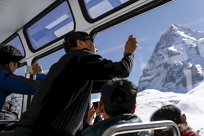 Am Fotografieren. Asiatische Touristen mit der Jungfrau-Bahn unterwegs zwischen Wengen und der Kleinen Scheidegg.