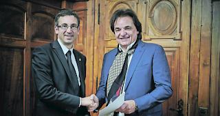 &Uuml;bergabe. Christian Constantin hat die Markenrechte stellvertretend f&uuml;r das Kandidaturkomitee an Staatsrat Fr&eacute;d&eacute;ric Favre abgetreten. 