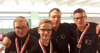 Die jungen Medaillengewinner No&eacute; Noti, Jan Anthamatten und Tim Williner (vlnr). Im Hintergrund Coach Willy Venetz.