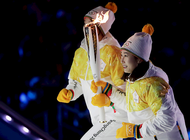 Jong Su Hyon (links) aus Nordkorea und Park Jong-ah aus Südkorea tragen die Fackel ins Stadion.