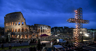 Ein mit Kerzen erleuchtetes Kreuz vor dem Kolosseum in Rom