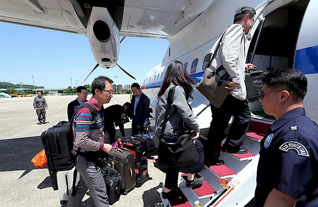 Grünes Licht. Südkoreanische Journalisten besteigen ein Flugzeug, um über die für diese Woche angekündigte Zerstörung eines Atomtestgeländes im Nordosten Nordkoreas zu berichten.