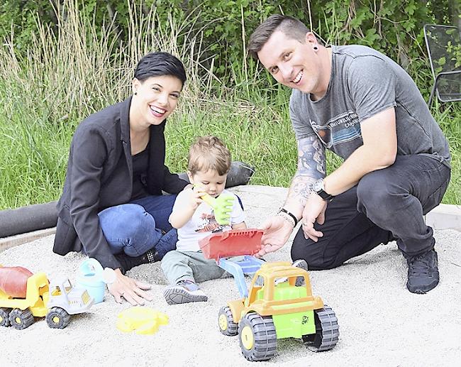 Aiden mit Mama und Papa im Sandkasten.