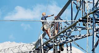 Harte Arbeit. Zwei Arbeiter f&uuml;hren in luftiger H&ouml;he Arbeiten an der Gommerleitung durch.Foto Keystone