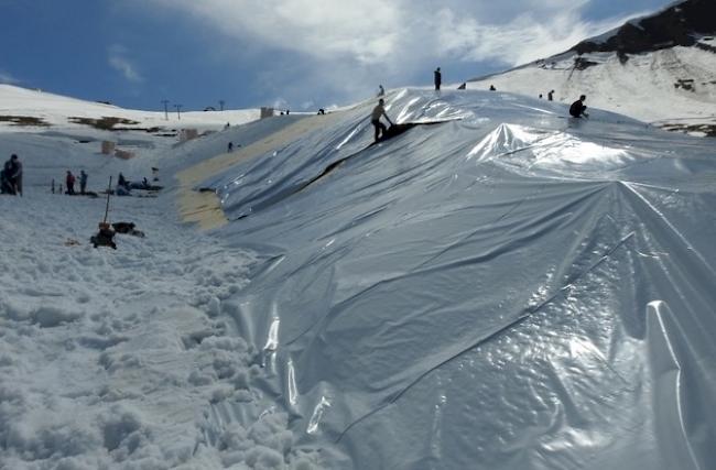 Auf der Tschentenalp wurde in Schneehaufen mit Dämmmatten und Kunsstofffolie eingepackt. Snowfarming nennt sich das Ganze.