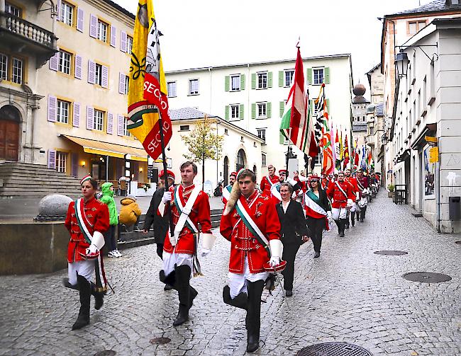 <b>Farbenfroher Umzug.</b> Die Fahnendelegationen laufen, von den Brigensern angeführt, durch die Briger Burgschaft.