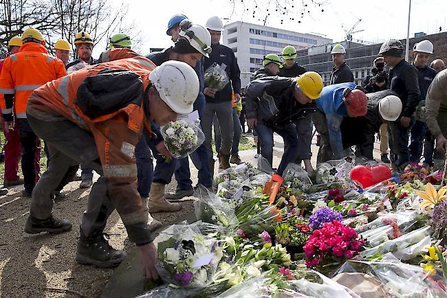 Bauarbeiter, die Zeuge der Schiesserei am Montag in einer Strassenbahn waren, brachten am Dienstag Blumen.