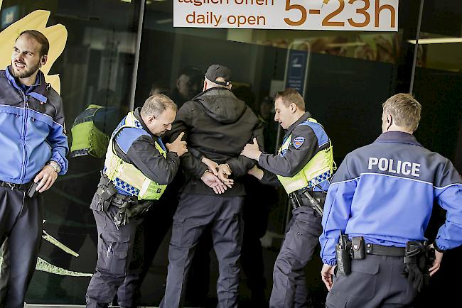 Polizisten überwältigen einen Bankräuber.