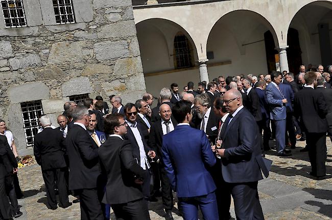 Gäste und Brüder im Schlosshof beim Apéro mit Hobelkäse und Roggenbrot.