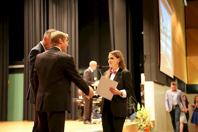 Bildungsminister Christophe Darbellay (hinten) und Olivier Mermod verteilen die OMS-Zertifikate.