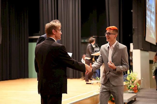 Bildungsminister Christophe Darbellay (hinten) und Olivier Mermod verteilen die OMS-Zertifikate.