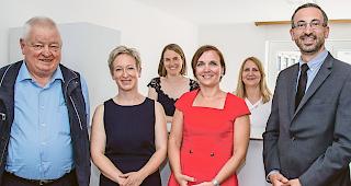 Vereint am neuen Ort. Ex-Amtsleiter Caesar Jaeger, neue Standortleiterin Christine &shy;Keller, Sekret&auml;rin Karin Schalbetter, Dienstchefin Sophie Huguet, Sekret&auml;rin Sabine &shy;Kalbermatten und Staatsrat Fr&eacute;d&eacute;ric Favre (von links).Foto WB/Andrea Soltermann