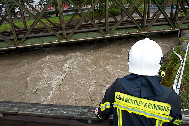 Ein Feuerwehrmann schaut in Monthey auf die SBB-Bahnlinie, die den Rhone-Nebenfluss Vièze überquert. (Archivbild von 2015)