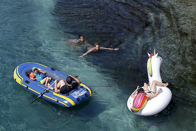 Menschen in Schlauchbotten kühlen sich Anfang August in der Rhone in Genf ab.