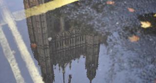 Das britische Parlament in London spiegelt sich in einer Pf&uuml;tze.