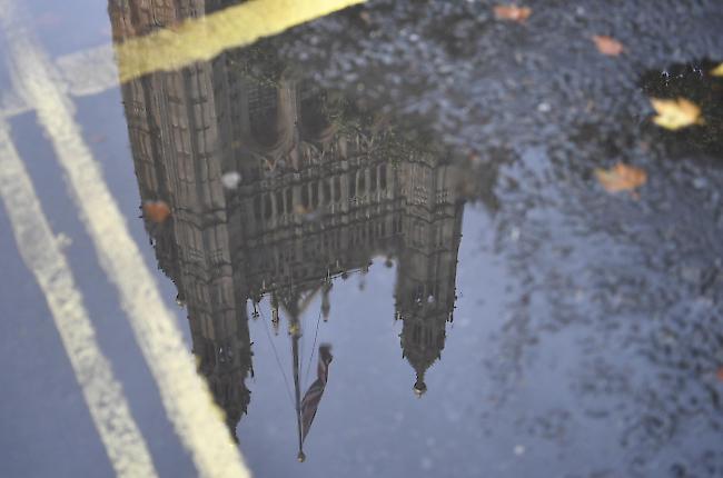 Das britische Parlament in London spiegelt sich in einer Pfütze.