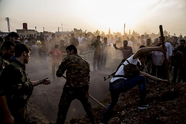 Syrer begraben am Samstag syrische Kämpfer der demokratischen Streitkräfte, die getötet wurden, als sie den türkischen Vormarsch in der syrischen Stadt Qamischli bekämpften.