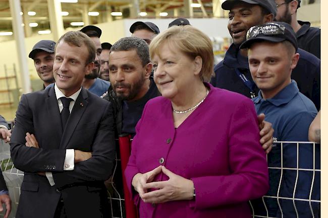 Besuch. Macron und Merkel posieren gemeinsam mit Airbus-Mitarbeitenden in Toulouse.