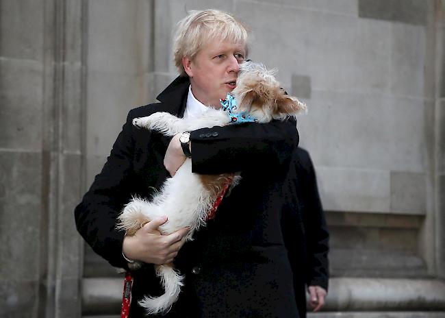 Der britische Premierminister und konservative Parteichef Boris Johnson hält nach der Wahl in der Methodist Central Hall seinen Hund Dilyn fest.