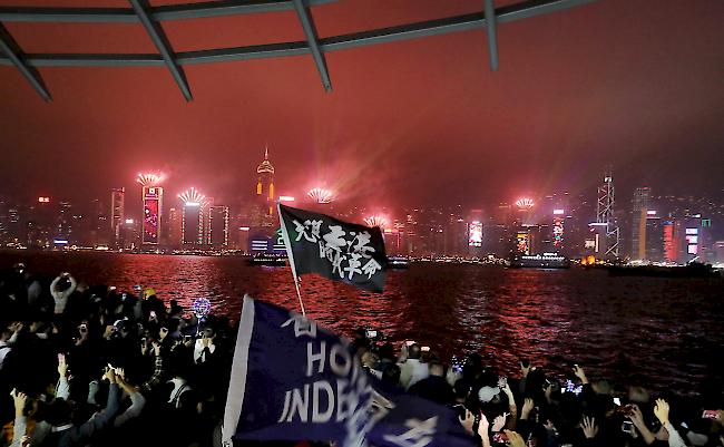 Hongkong: Protestierende singen, während Feuerwerkskörper entlang der Uferpromenade in Tsim Sha Tsui explodieren.