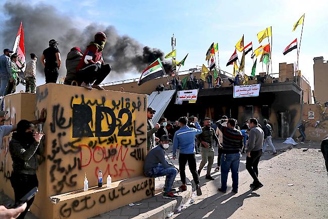 Pro-iranische Milizionäre und ihre Unterstützer legten am Mittwoch während eines Sitzstreiks vor der US-Botschaft in Bagdad, Irak, ein Feuer.
