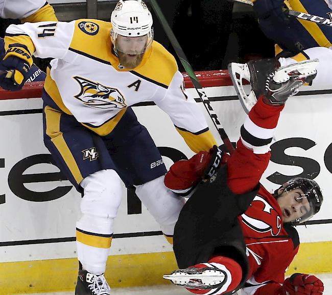 Nico Hischier (rechts) stürzt nach einer Kollision mit dem Schweden Mattias Ekholm, Verteidiger bei den Nashville Predators.