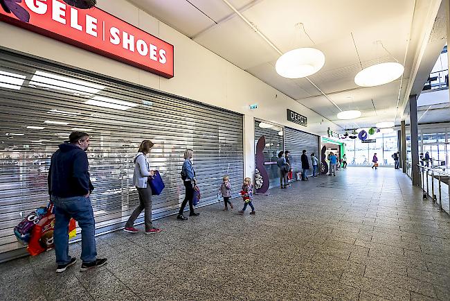 Einer nach dem anderen. Aufgrund der Ansteckungsgefahr werden die Menschen nur in kleinen Gruppen in die Geschäfte gelassen – Bild: Simplon-Center in Glis. 