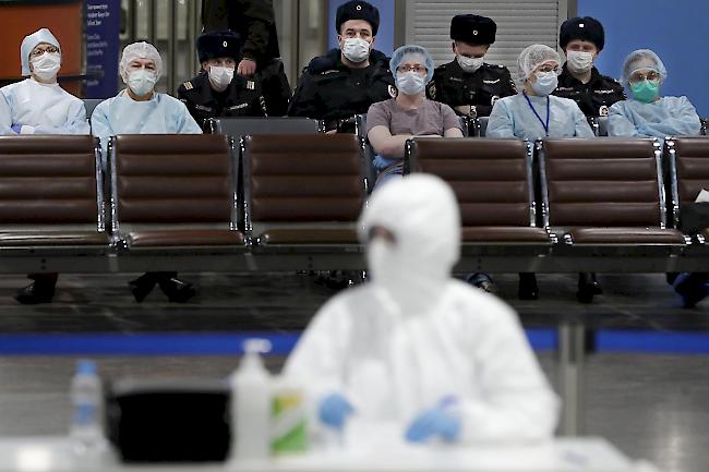 Russische Medizin-Experten und Polizisten machen eine Pause, während...