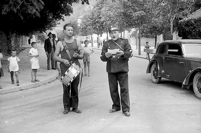 September 1939. In Sitten verkündet der Gemeindepolizist Amacker die Mobilmachung für den Zweiten Weltkrieg.