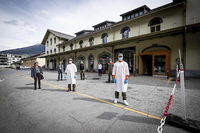 Vor dem ambulanten Abklärungszentrum in Brig-Glis. Dr. Monique Lehky Hagen, Dr. René Blumenthal, Adrian Zenklusen vom Zivilschutz in Schutzkleidung, Zivilschutzkommandant Silvan Lorenz, Dr. Christine Baumann, Simon Karlen und Alessandro Walker (von links) mit dem nötigen Abstand.